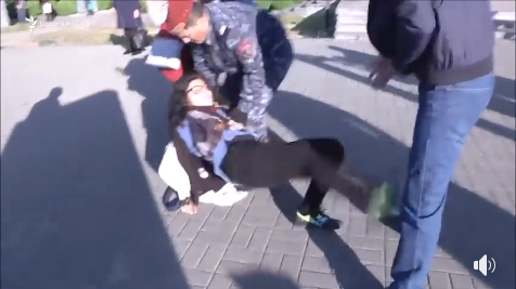 Polis gənc qızı yerdə sürüdü, sonra maşına mindirdi - VİDEO